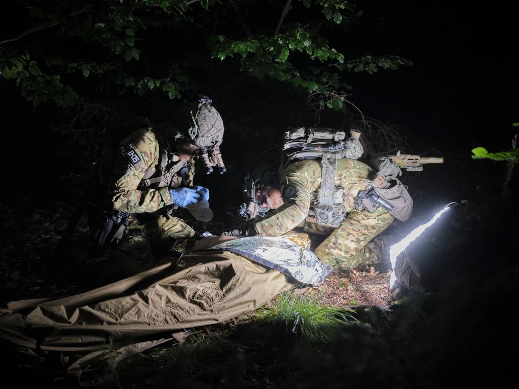 Taktische Verwundetenversorgung bei Nacht im Wald, ausgeleuchtet durch eine XP Light Matte